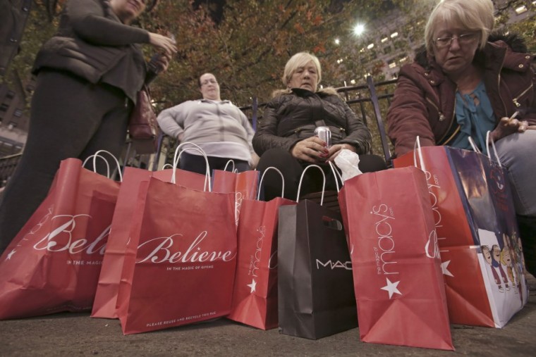 Women sit outside after shopping at Macy's Herald Square store during the early opening of the Black Friday sales in Manhattan. REUTERS/Andrew Kelly