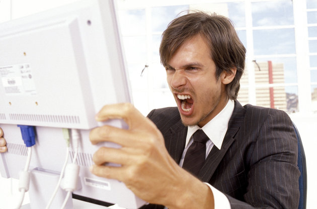 Businessman yelling at a computer monitor