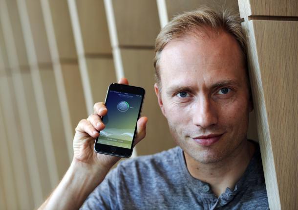 Co-founder of sweatcoin Oleg Fomenko poses for a photograph with the sweat coin app open at his office in London, Britain May 4, 2016. REUTERS/Paul Hackett